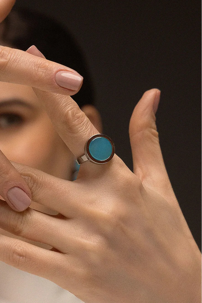O Anel Eterno - Ágata Azul Céu, da Coleção Singular, une a serenidade das águas à sofisticação do acabamento escuro. A Ágata Azul Céu é reconhecida por promover calma, clareza mental e harmonia nas emoções, criando um contraste moderno e impactante com o metal escuro. Banhado a Ródio Negro, este anel de design contínuo e imponente destaca a suavidade da pedra, sendo a peça ideal para mulheres que buscam um acessório contemporâneo que transmita paz interior com uma personalidade forte.