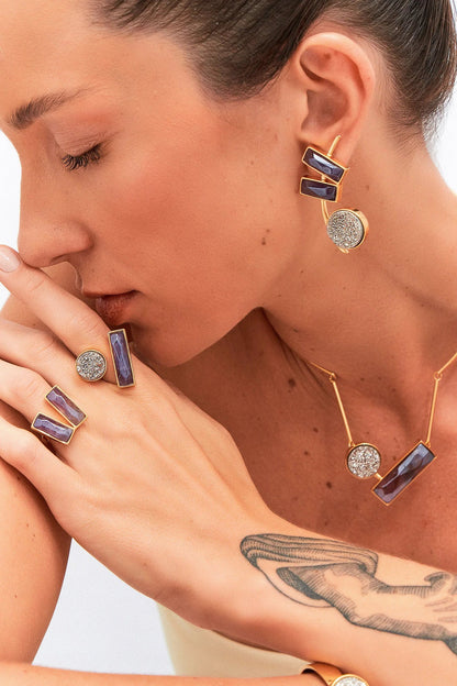 O Anel Harmonie - Ametista, da Coleção Convicta, é uma joia que combina a elegância do Banho de Ouro 18K com a beleza e o poder da Ametista. Esta gema púrpura é ideal para quem busca elevar a espiritualidade, promovendo sabedoria, proteção e a transmutação de energias negativas. Seu design Harmonie, com lapidação multifacetada, oferece um toque de sofisticação e propósito ao visual.