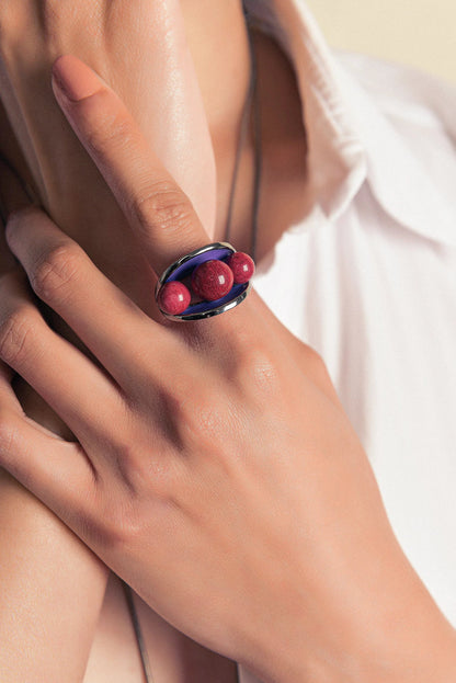 O Anel Sublime em Esmaltado Roxo e Feldspato Vermelho, com Banho de Ouro 18K, é uma peça de contraste elegante e marcante. O Feldspato Vermelho Liso harmoniza-se com o esmalte em tom roxo, criando um visual sofisticado que contrasta com o brilho do ouro.