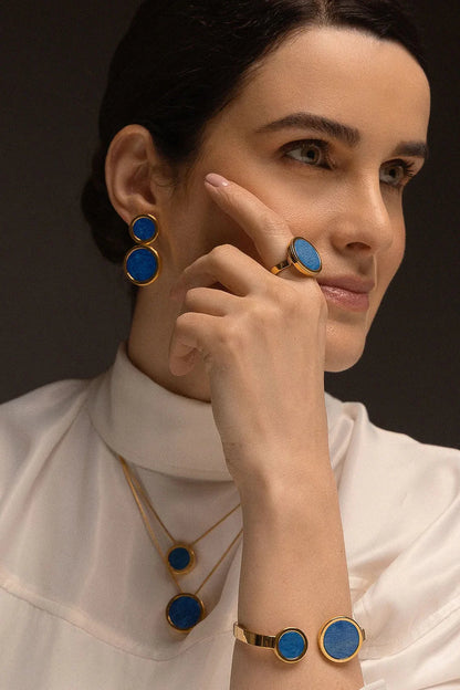 O Anel Único - Feldspato Azul Anil faz parte da Coleção Singular, que destaca a exclusividade e o valor individual de cada mulher. O Feldspato Azul Anil é uma pedra que favorece a intuição, a autoconfiança e a clareza mental. Com um design imponente e banhado a Ouro 18K, esta joia transforma a simplicidade em uma peça magnífica, perfeita para quem deseja expressar sua força com elegância e serenidade.