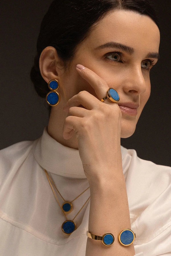 O Anel Único - Feldspato Azul Anil faz parte da Coleção Singular, que destaca a exclusividade e o valor individual de cada mulher. O Feldspato Azul Anil é uma pedra que favorece a intuição, a autoconfiança e a clareza mental. Com um design imponente e banhado a Ouro 18K, esta joia transforma a simplicidade em uma peça magnífica, perfeita para quem deseja expressar sua força com elegância e serenidade.