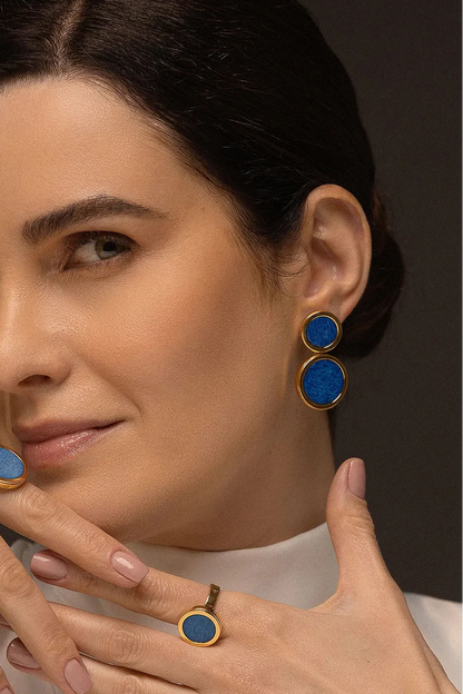 O Brinco Nobre - Feldspato Azul Anil, integrante da Coleção Singular, é uma joia de elegância profunda e magnética. O Feldspato Azul Anil é uma pedra associada à expansão da consciência, à intuição e à clareza mental, evocando a serenidade dos oceanos e a imensidão do céu. Banhado a Ouro 18K, este brinco de design imponente destaca a cor intensa e o brilho sofisticado da gema, sendo a peça ideal para mulheres que buscam um acessório de presença marcante e significado espiritual.